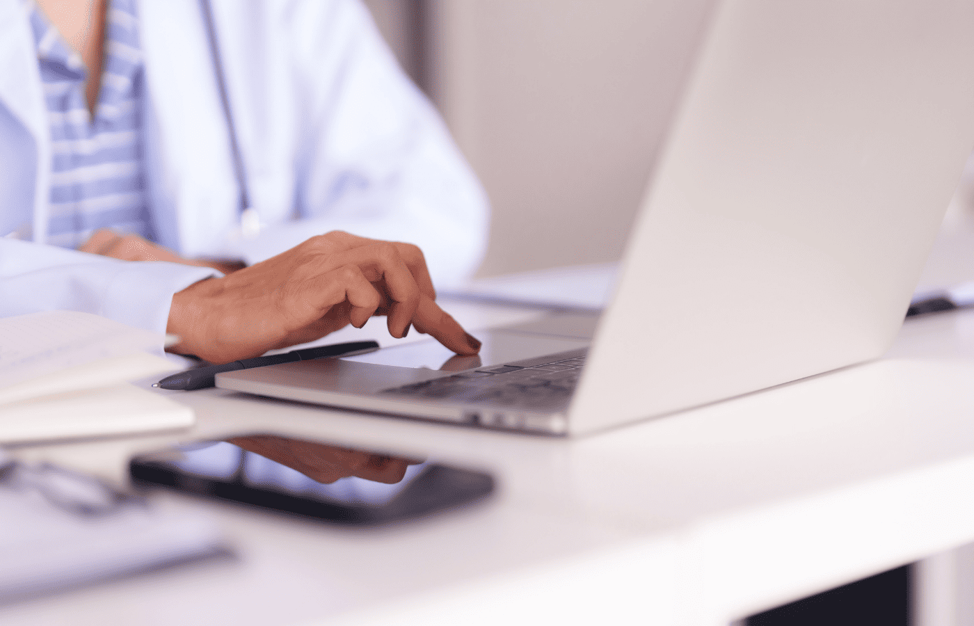 Healthcare professional using a laptop for manual data abstraction during EHR migration, emphasizing data accuracy and quality assurance.