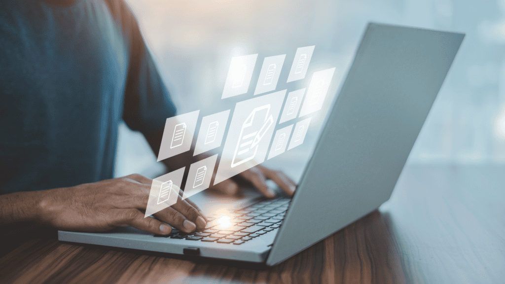 Person typing on laptop with digital document icons representing real-time document management and QI data elements in clinical settings.