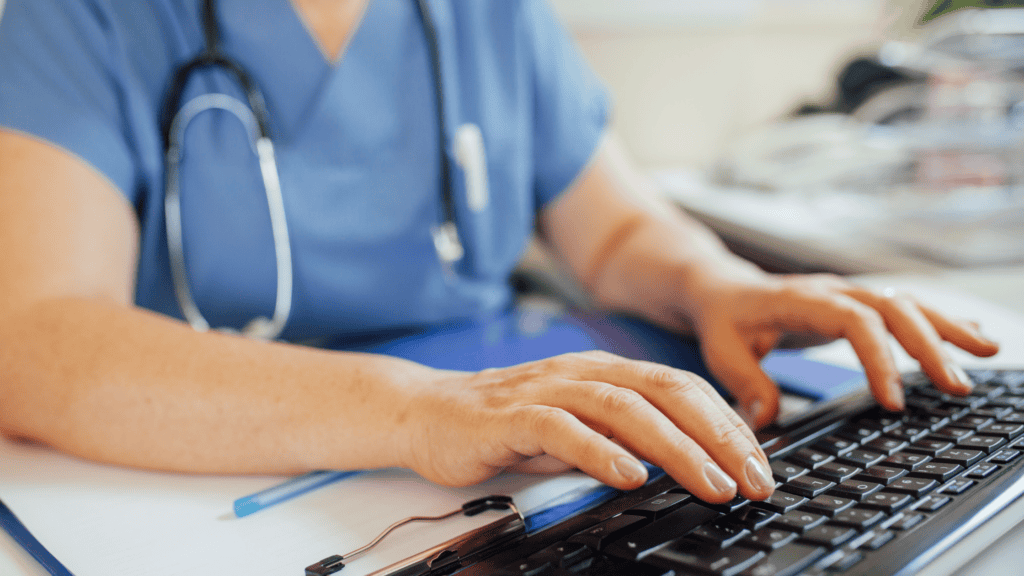 Healthcare professional typing on a keyboard, emphasizing virtual prior authorization process and reducing administrative burden for improved patient care.