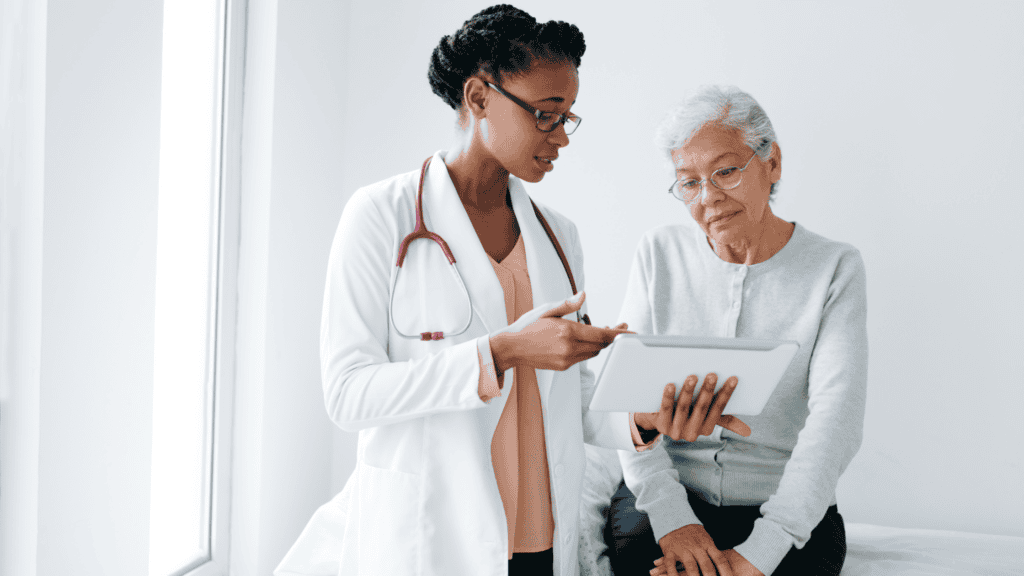 Healthcare professional discussing insurance verification with patient on tablet, emphasizing efficient communication and patient care in medical settings.